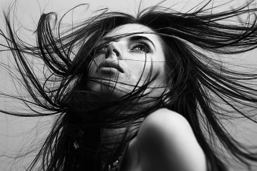 Beautiful fashionable young girl with flying hair