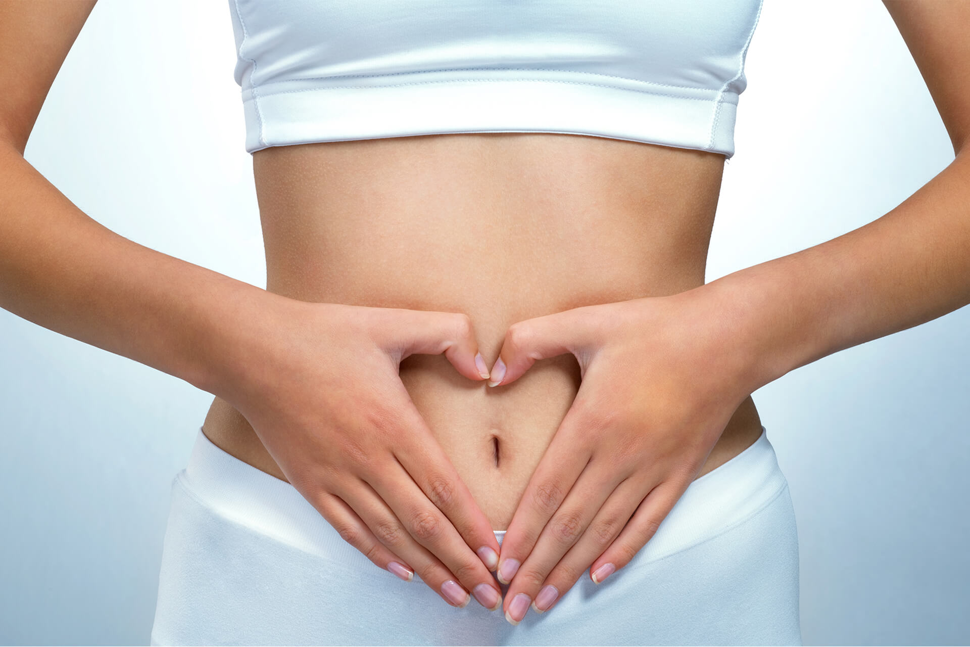 heart shaped hands on woman stomach