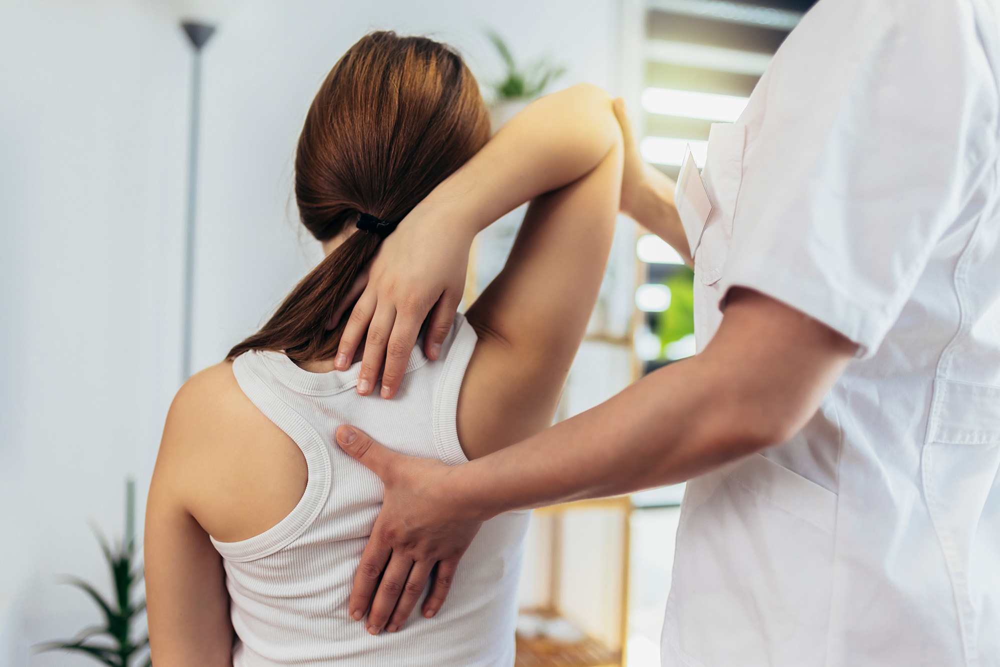 Teen Girl having chiropractic back adjustment. Osteopathy, Physiotherapy, Kinesiology. Bad posture correction