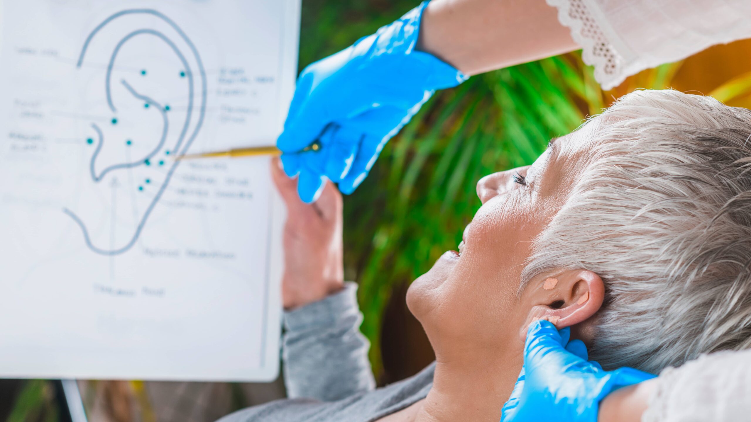 Patient learning about ear points in auriculotherapy treatment.