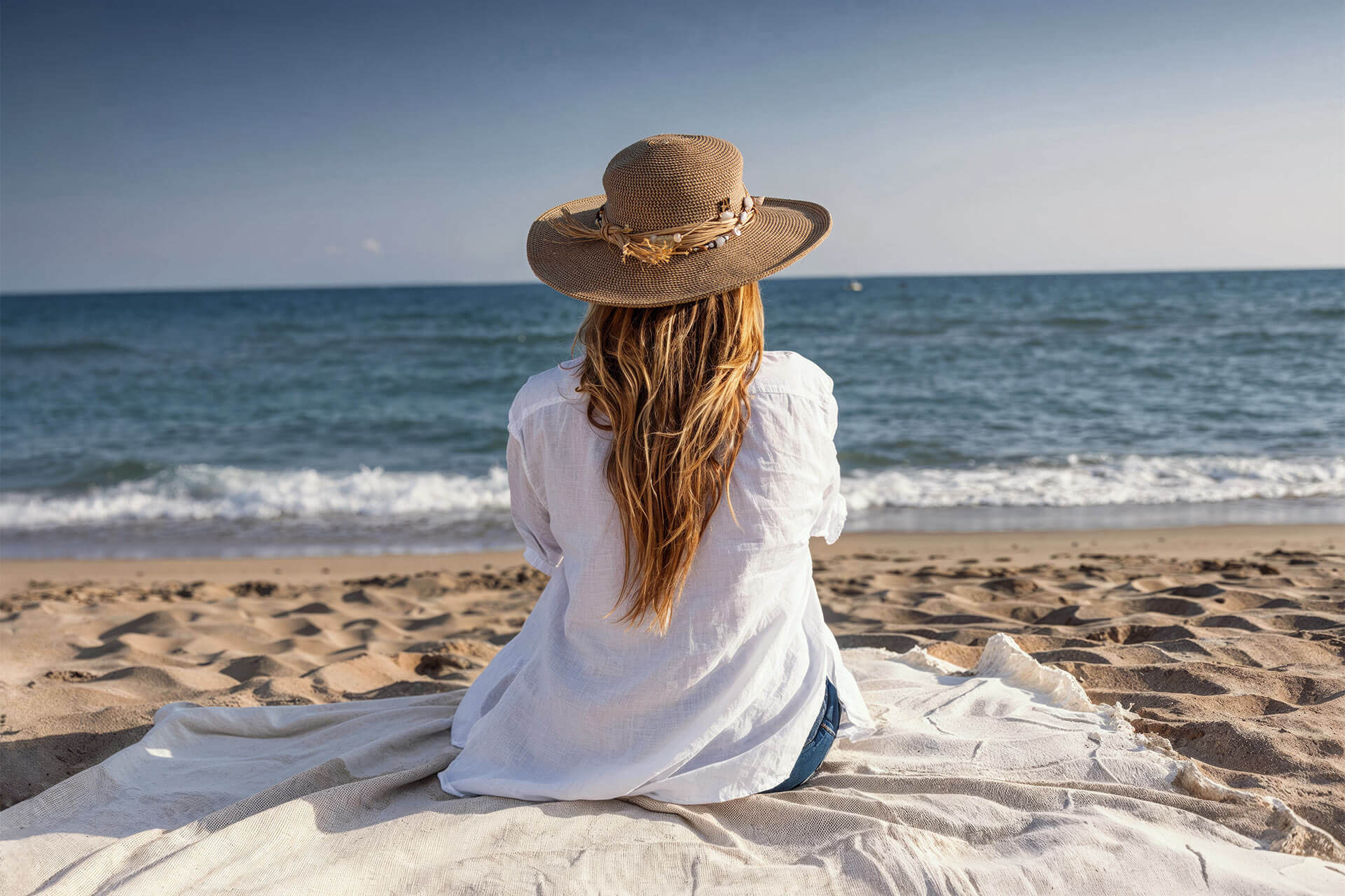 Young woman sitting on the beach