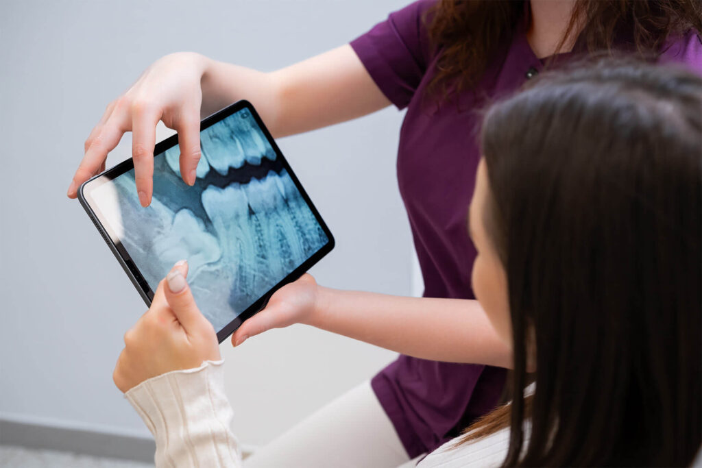 A dental professional examines a digital dental chart