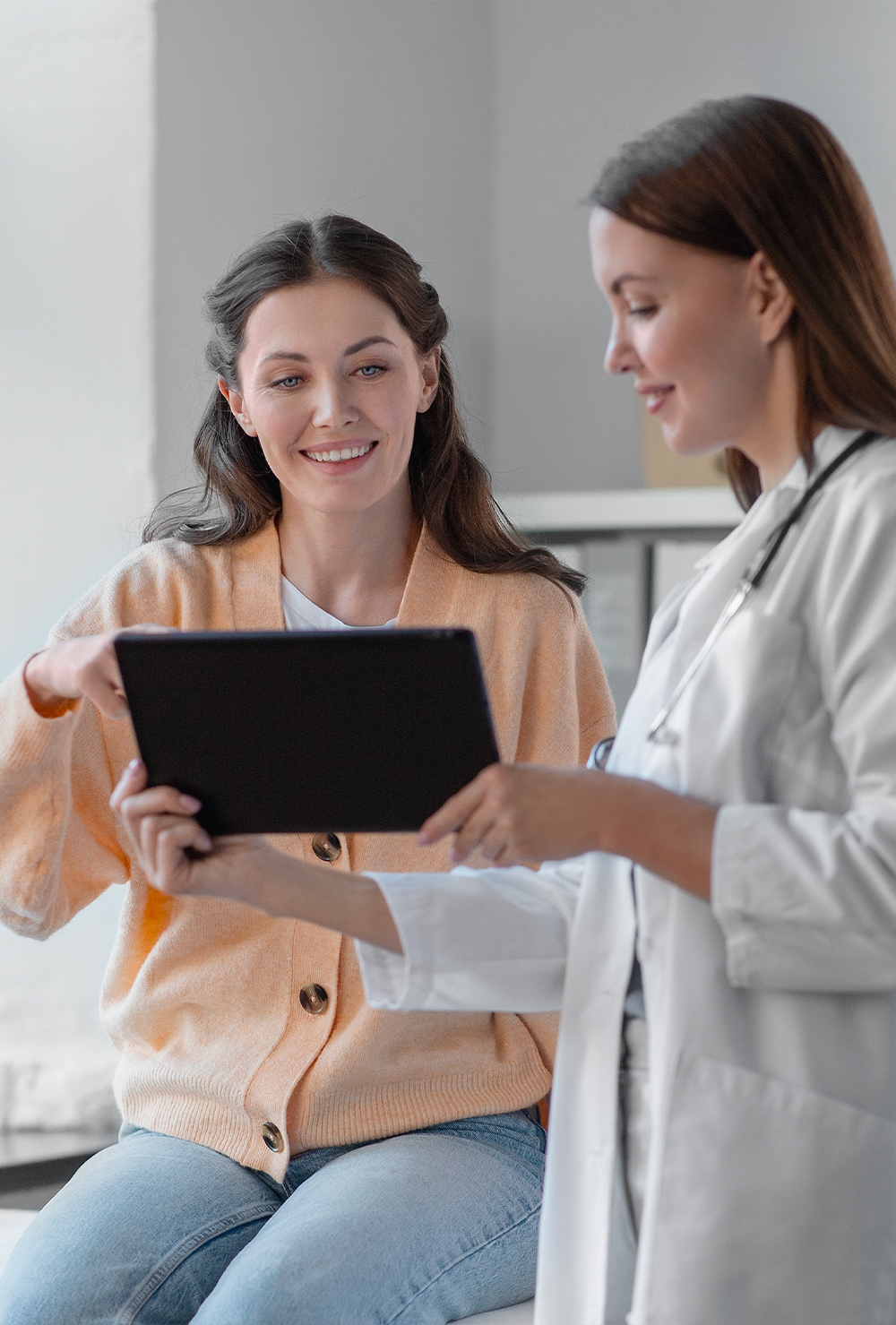 female doctor showing the patient on a tablet