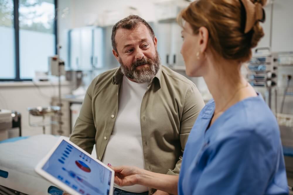Female doctor consulting with overweight patient, discussing test result in doctor office.