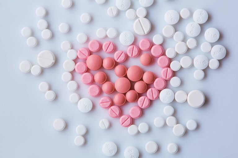 Pink and white tablet pills forming heart shape