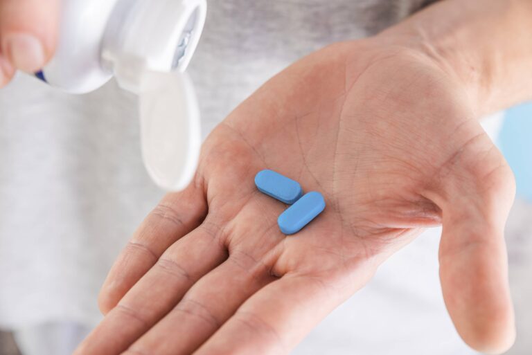 Blue medical pills on palm