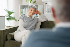 Psychology, therapist and woman on sofa with smile, counseling and hope for anxiety management