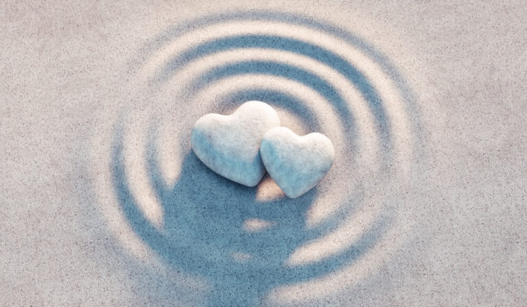 two heart-shaped stones placed in the center of concentric circles