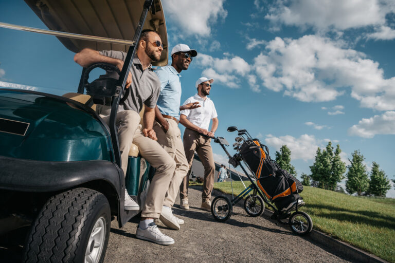 group of friends standing near a golf cart