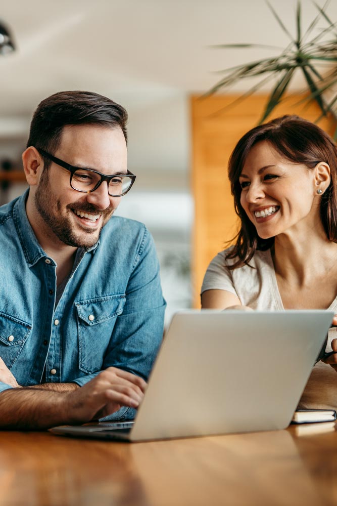 couple smiling on a laptop
