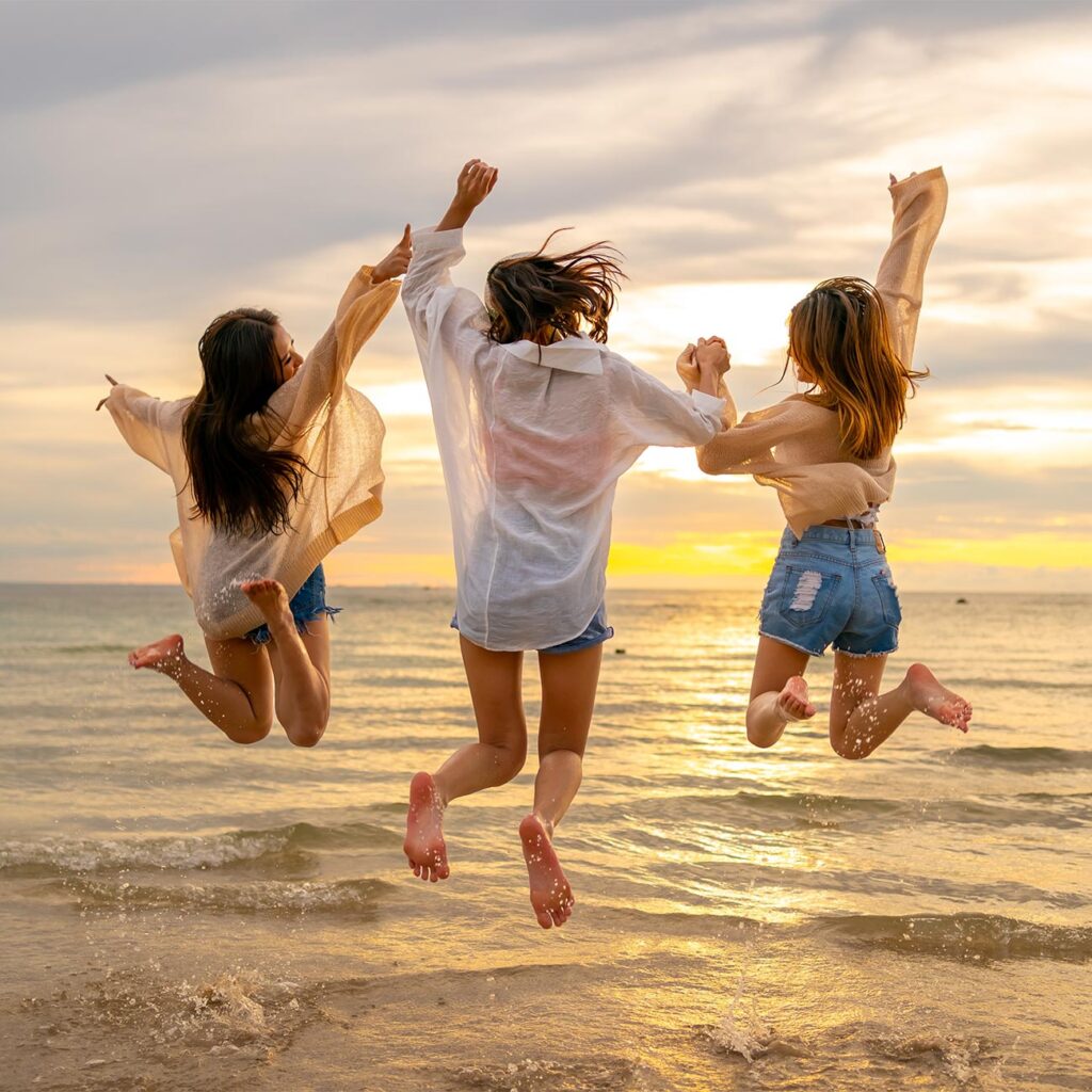 Group of friends jumping at beach