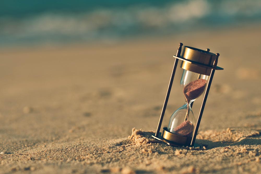 An hour glass on beach sand