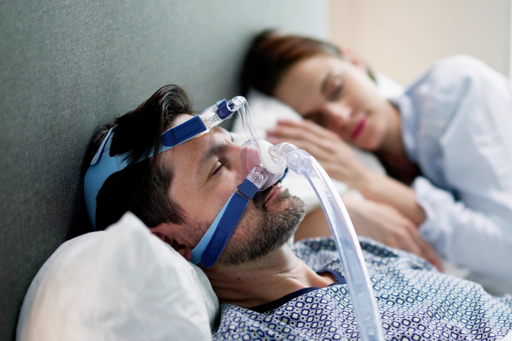 Woman wearing sleep apnea CPAP mask machine disorder.