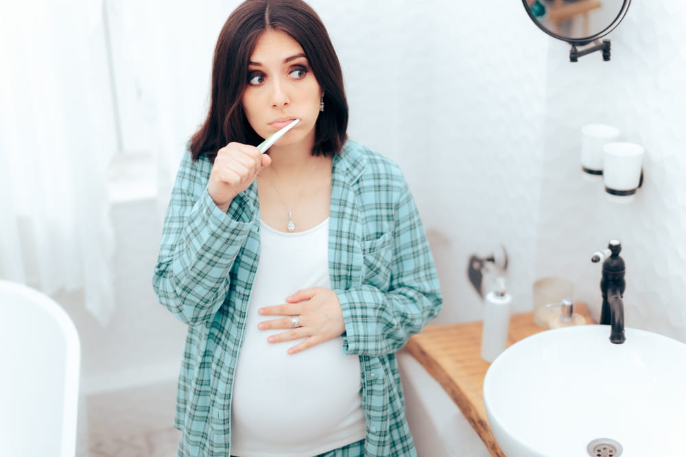 Pregnant Woman Brushing Her Teeth in the Bathroom