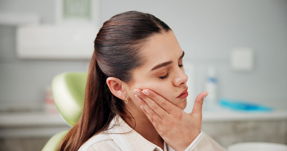 Woman, toothache and stress at dentist with pain, cavity or rotten tooth at oral care clinic.