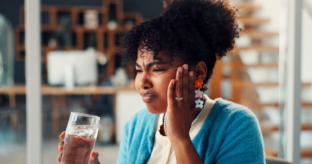 oothache, cold water and woman in office with pain, cavity or dental emergency in morning