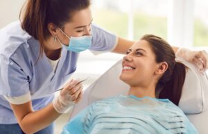 Doctor dentist or nurse conducting a medical checkup of a patient in a clinic, using a dental instrument
