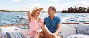 Laughing, happy couple and on a boat for retirement travel, summer freedom and holiday in Bali.