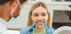 Portrait of beautiful smiling caucasian woman looking in mirror, checking her teeth in modern mental clinic