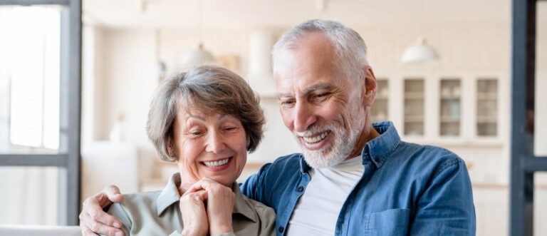 Smart caucasian old elderly senior grandparents couple spouses using cellphone for scrolling social media