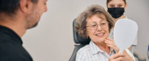 Pensioner at a dentists appointment looks at her teeth in the mirror