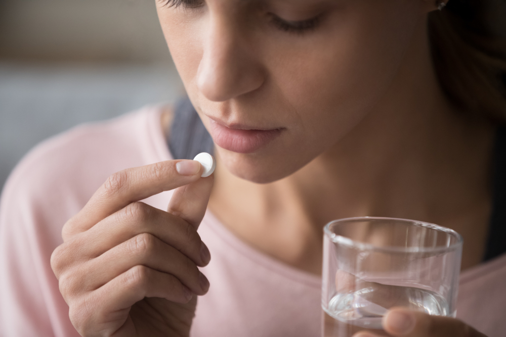 image millennial multiracial girl holding pill and glass of fresh water taking medicin