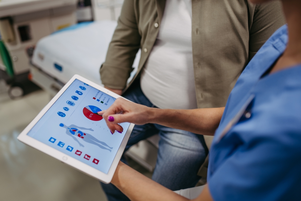 Close up of female doctor consulting with overweight patient, discussing test result in doctor office