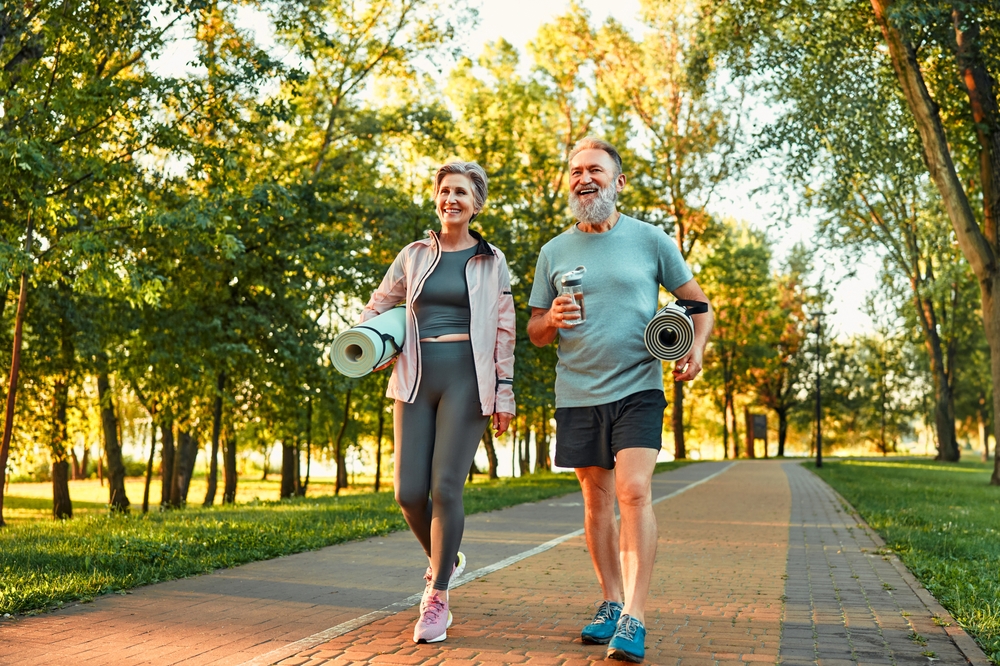 Beautiful sporty healthy active cheerful smiling middle-aged couple going to workout outdoors