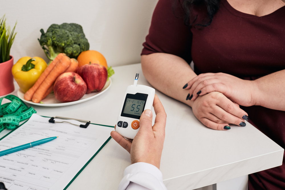 Measuring blood sugar. Nutritionist using glucometer tests overweight woman's blood sugar
