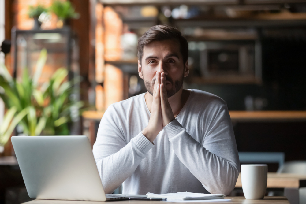stressed man put hands in prayer pray with hope pondering reflecting concerned about problem challenge