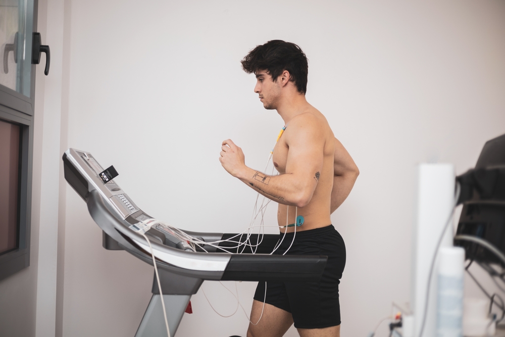 A young athlete undergoes a stress test on a treadmill