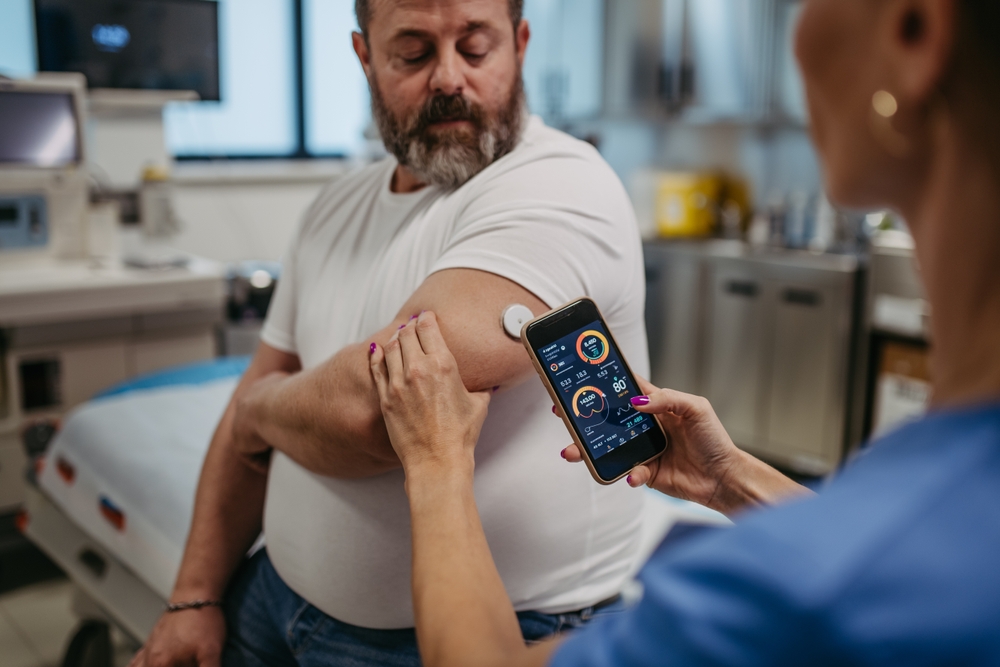 Doctor connecting continuous glucose monitor with smartphone