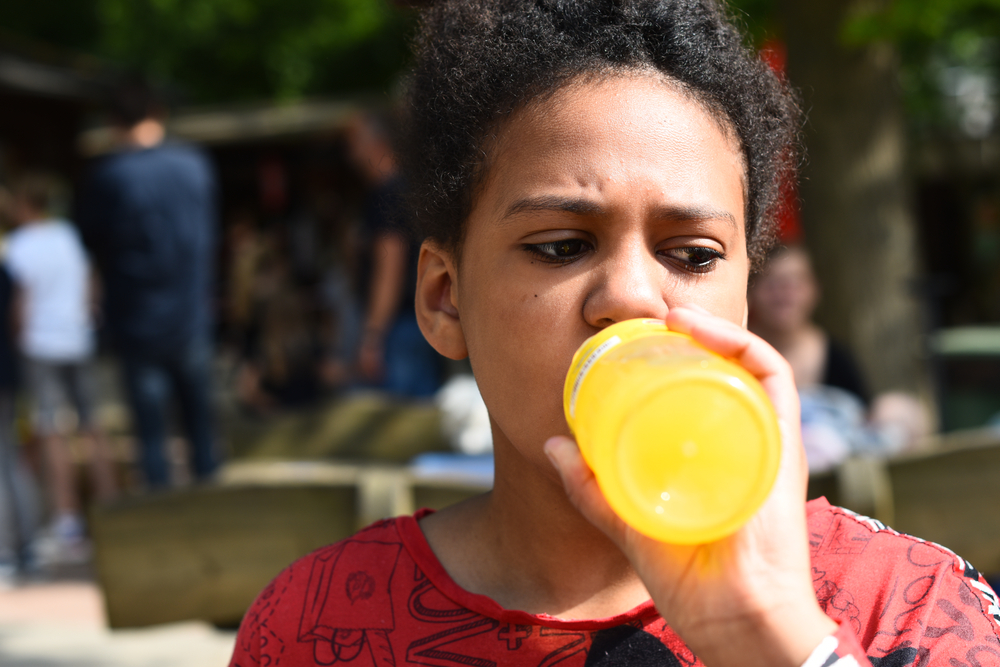 child drinking high sugar fizzy drink out of bottle