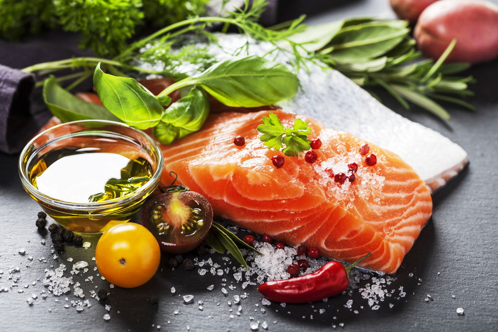 Delicious portion of fresh salmon fillet with aromatic herbs, spices and vegetables
