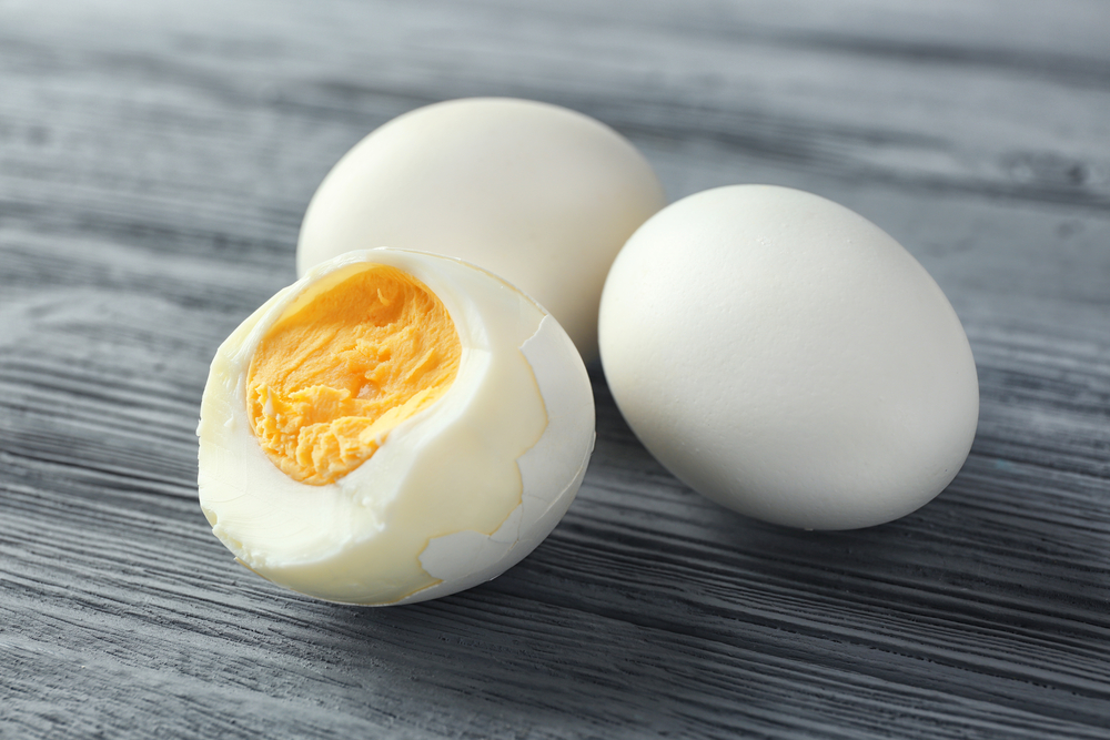 Hard boiled eggs on wooden table.