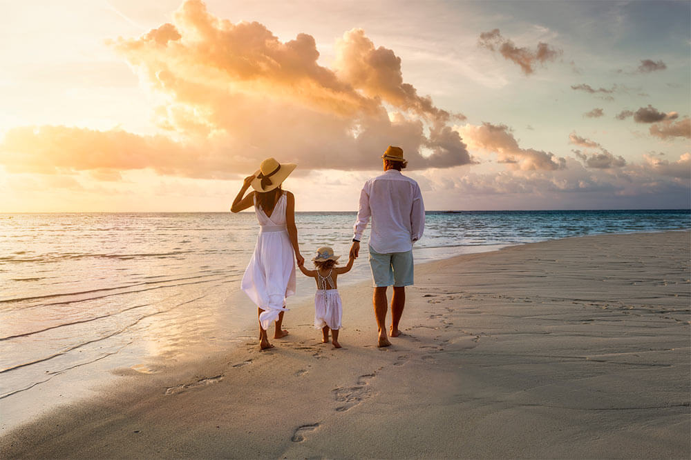 A elegant family in white summer clothing walks hand in hand