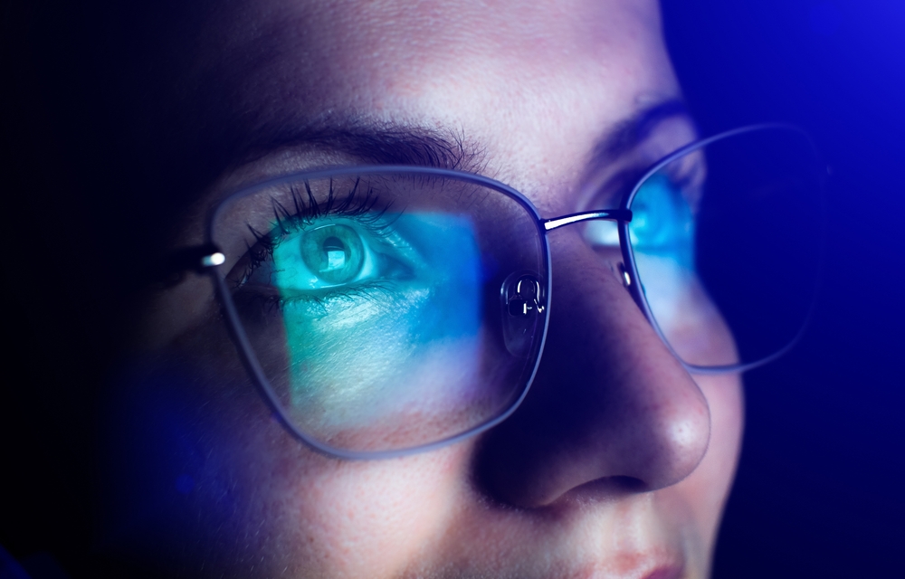 Girl works on internet. Reflection at the glasses