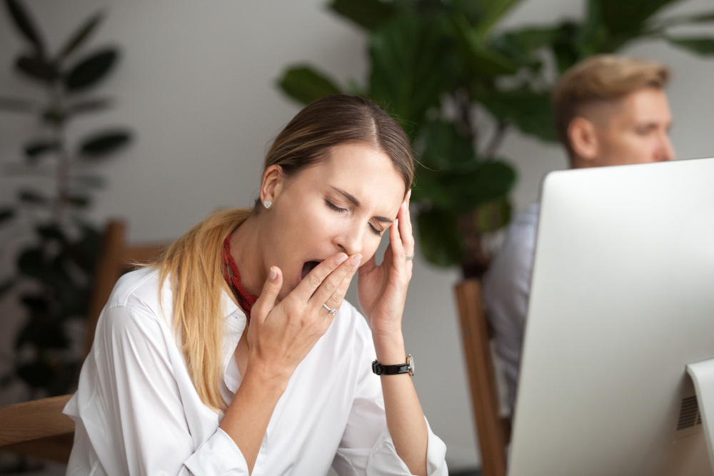 businesswoman yawning at workplace feeling no motivation or lack of sleep tired of boring office routine