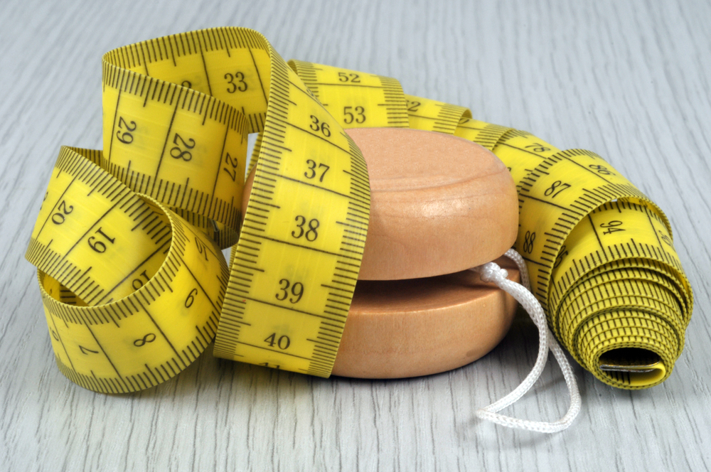 Yoyo diet concept with flexible tape measure close-up