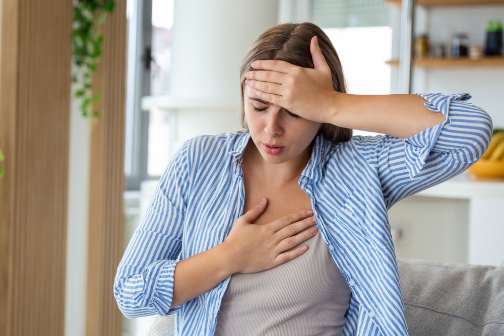 portrait of woman received heatstroke in hot summer weather, touching her forehead