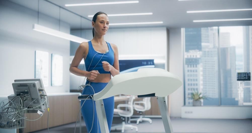 Female Athlete Wearing Headset for Cardiopulmonary Exercise Test on Treadmill in High-tech Medical Laboratory