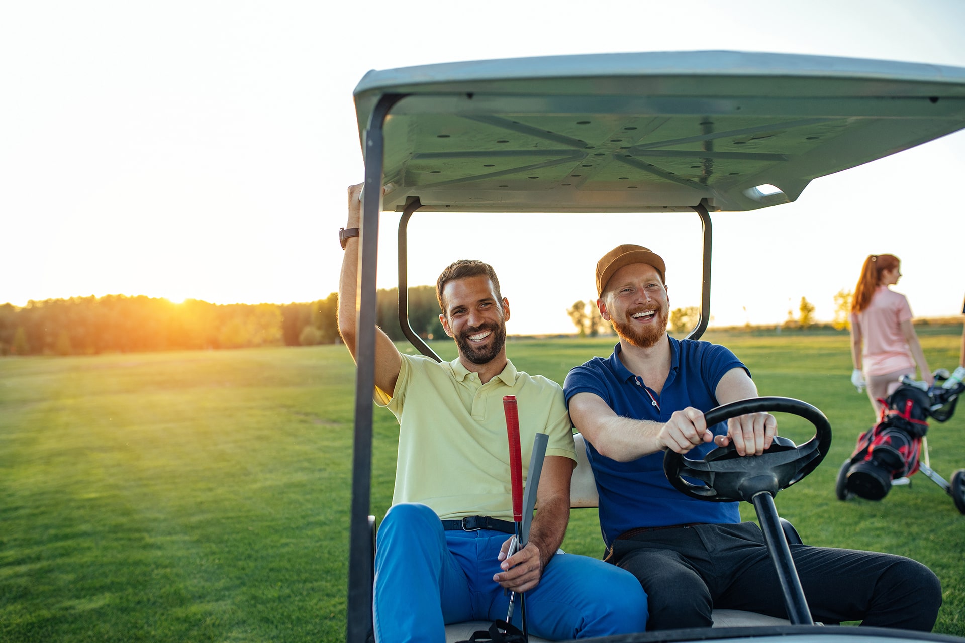 Young golfers driving in a cart on a golf course