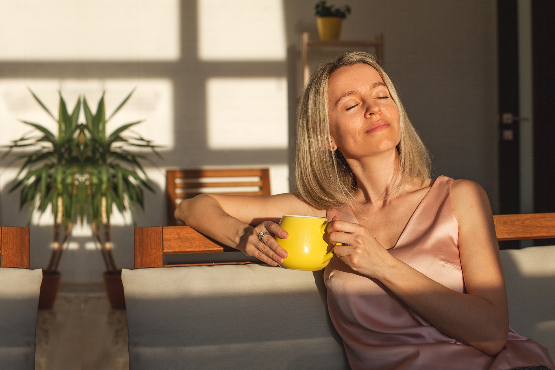 Satisfied middle aged woman is sitting on couch at home