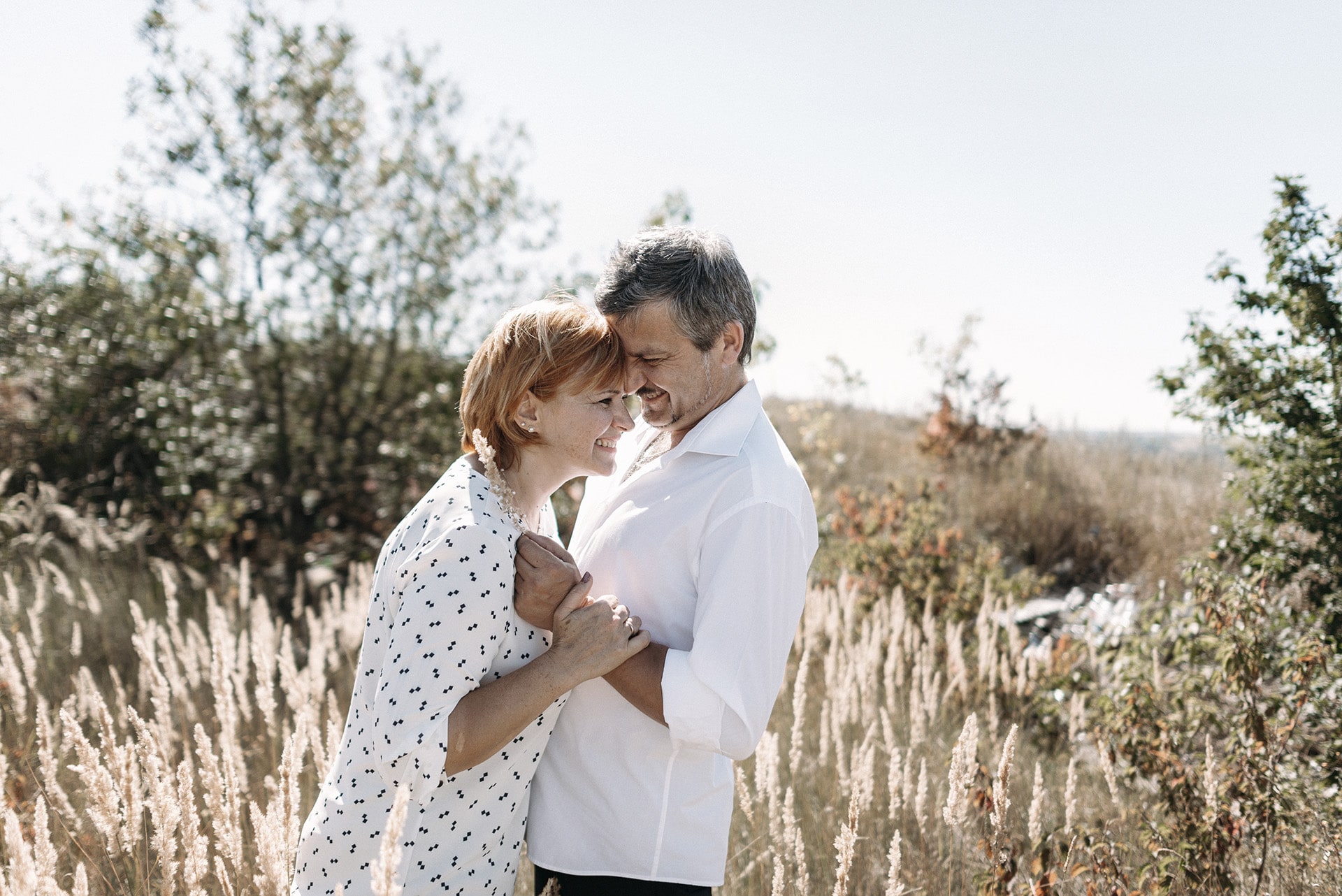 middle-aged couple walks in places with a high yellow grass