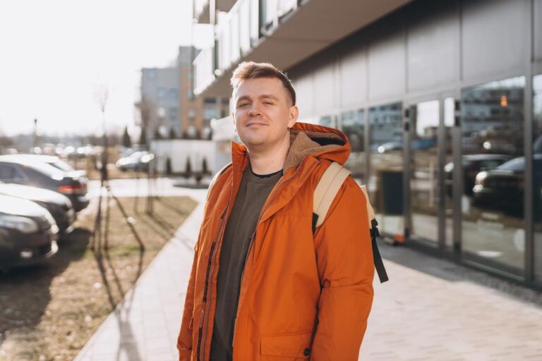 A handsome young man with backpack walking on the street