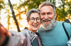Wonderful sincere cheerful couple of gray haired mature smiling people taking selfie portrait on phone.