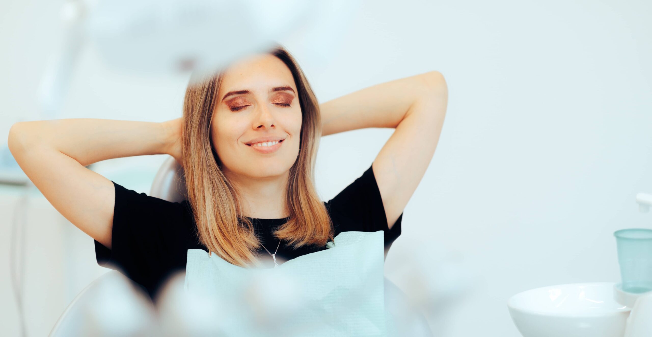 Happy Relaxed Patient Sitting in a Dental office. Carefree woman happy with the results after dental treatment