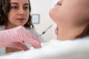 close up of Botox injection for chin beauty treatment in young woman by doctor: dermatology procedure