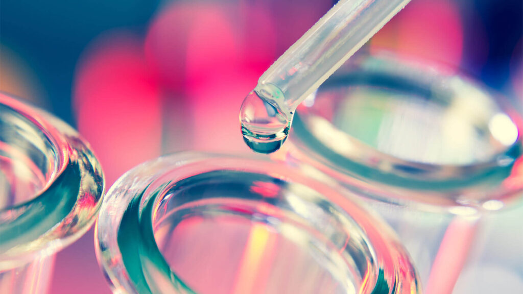 a liquid is being transferred using a dropper into test tube