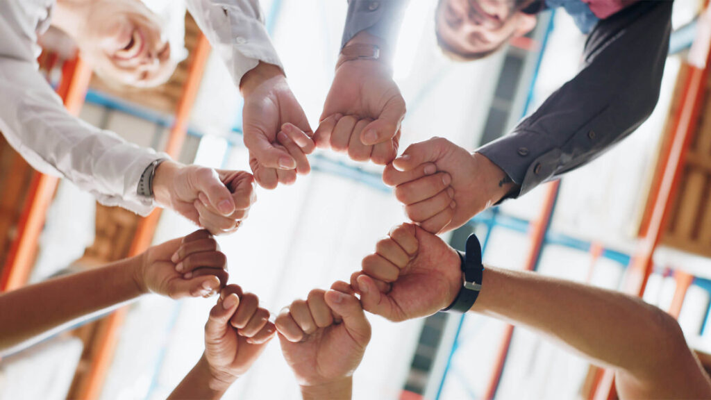 a group of people with their fists joined in a circle